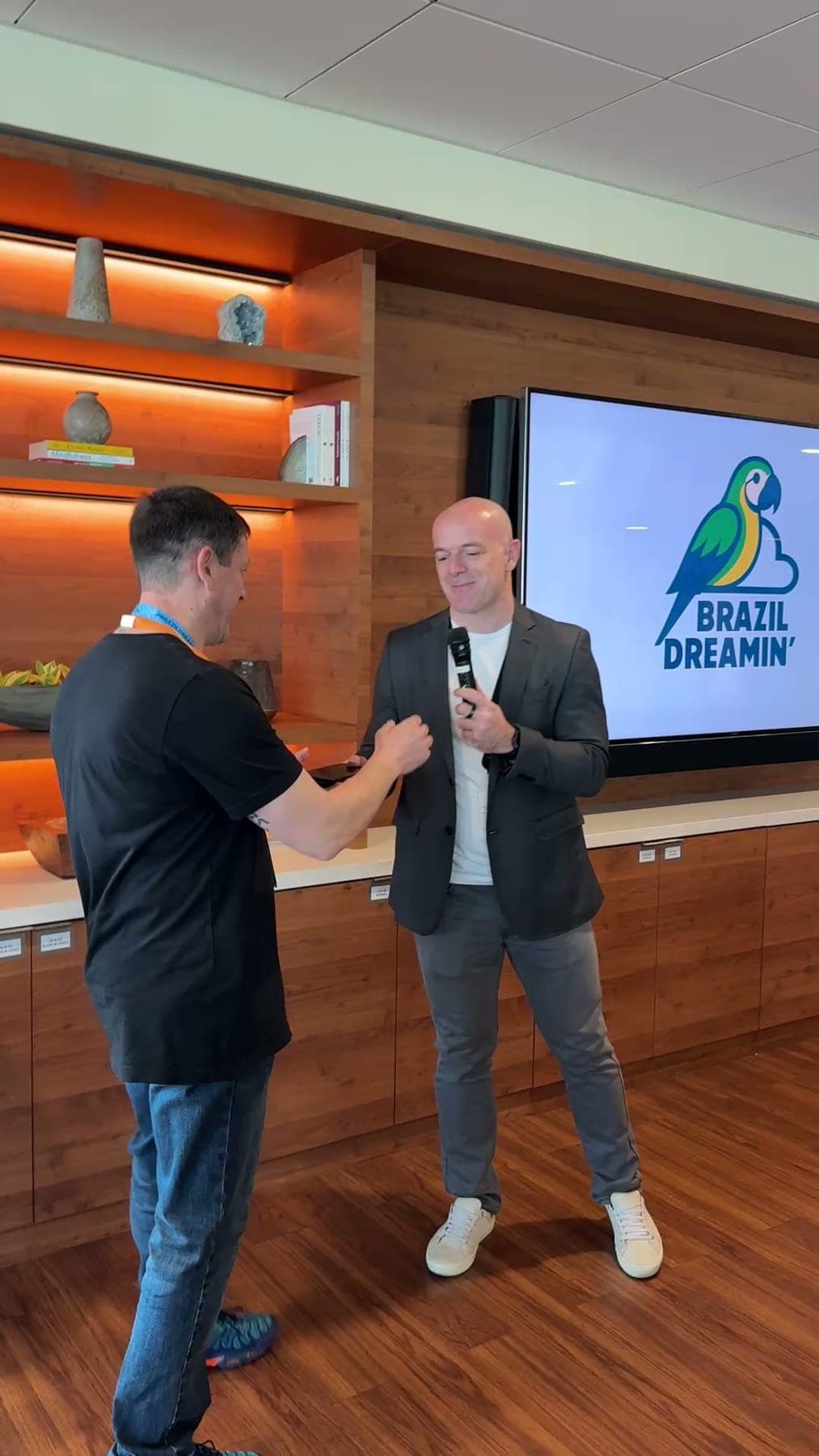 Dois palestrantes no palco com o logo do Brazil Dreamin’ na tela