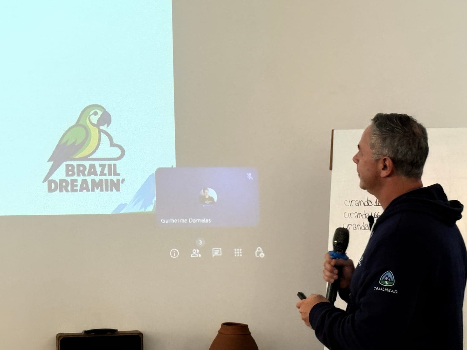 Palestrante ao lado da marca do evento projetada